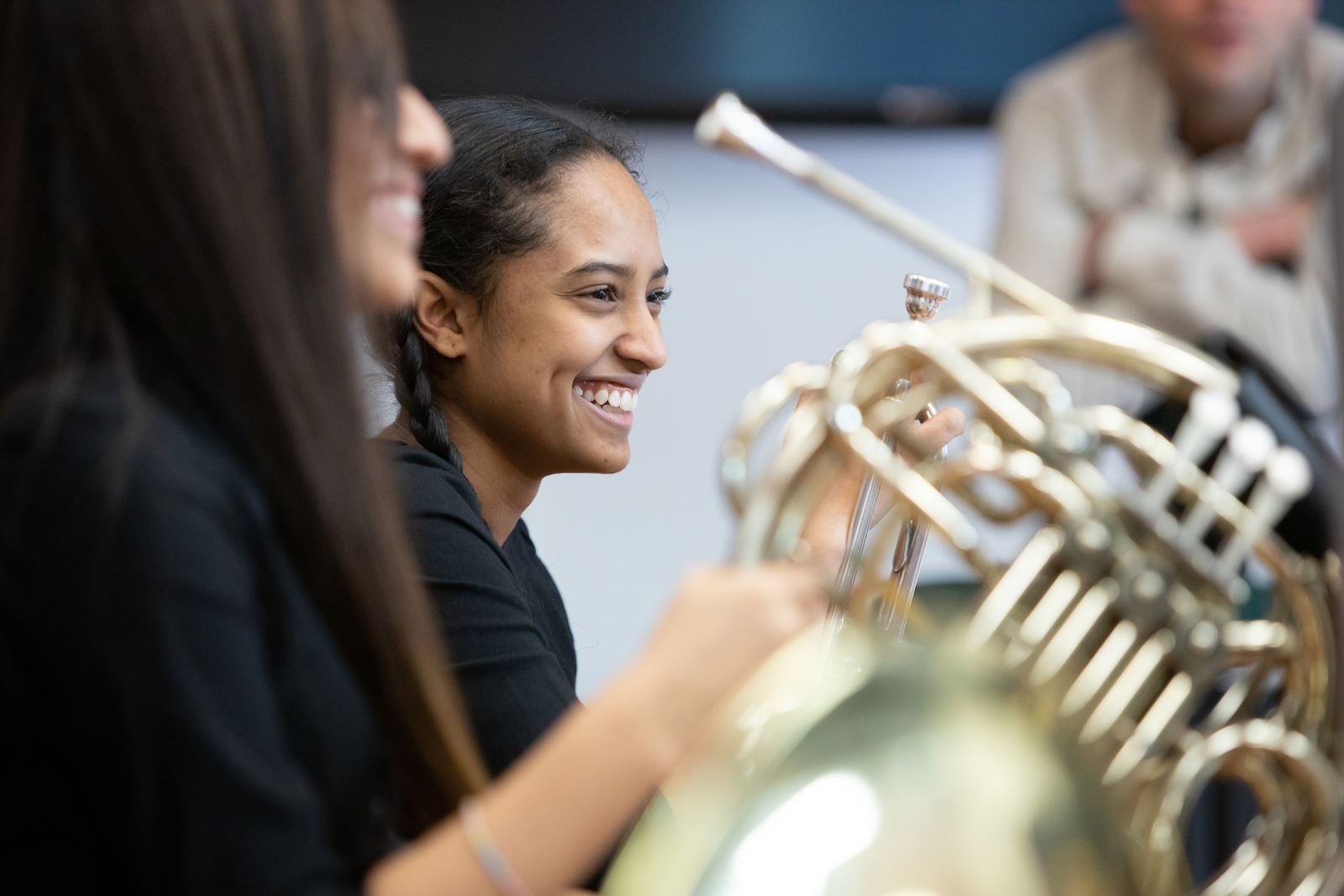 Teenage girl smiling during brass quintet rehearsal